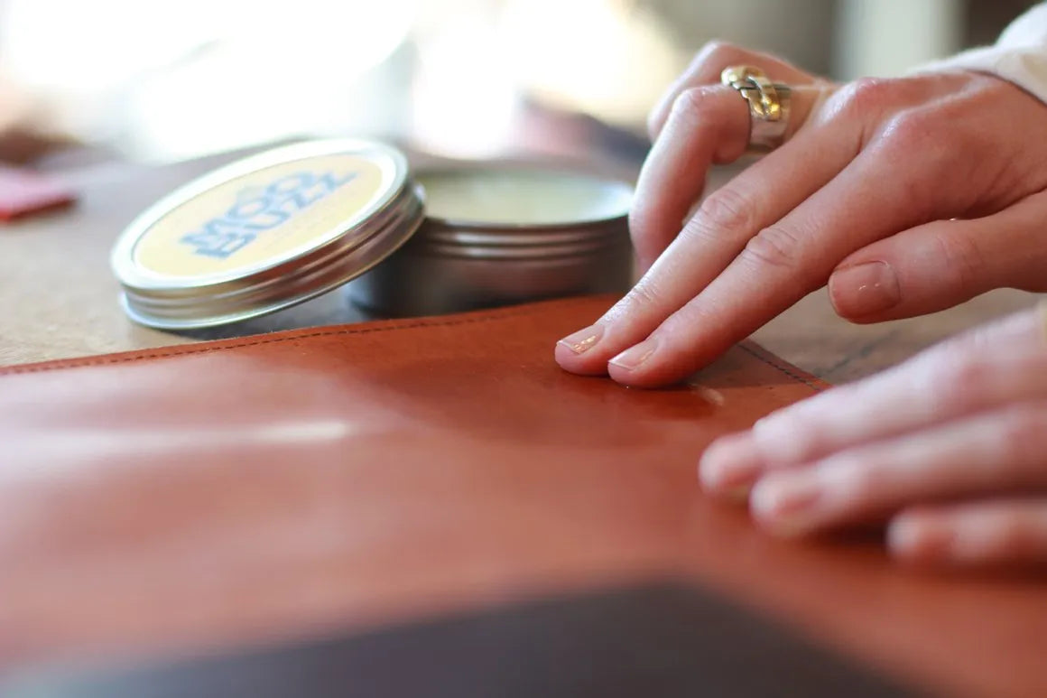 hands applying product to leather